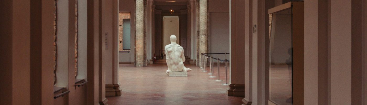 Couloir vide du musée avec une statue de marbre à la fin
